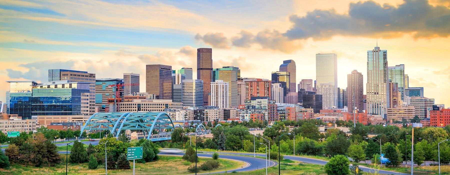 a city skyline with a park and a bridge